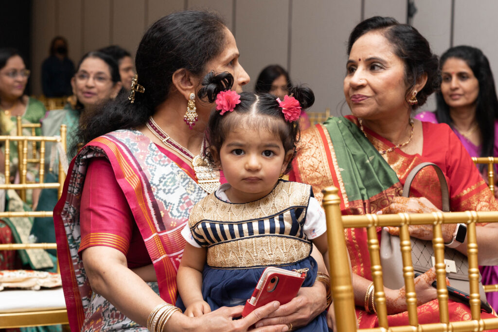 Little girl looking at camera during Indian wedding ceremondy