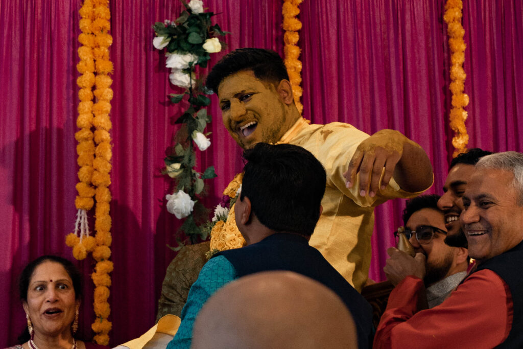 groom after yellow turmeric paste is applied