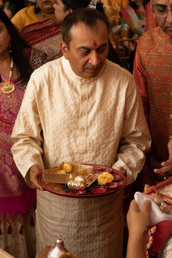Priest giving out Haldi snacks