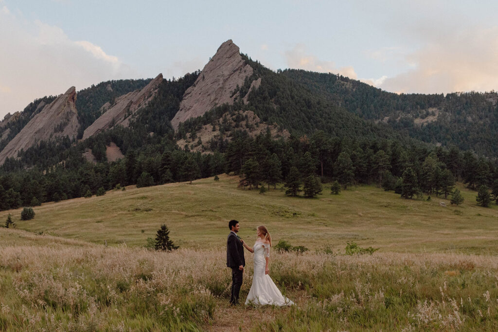 a Bride and groom under the flatirons in boulder