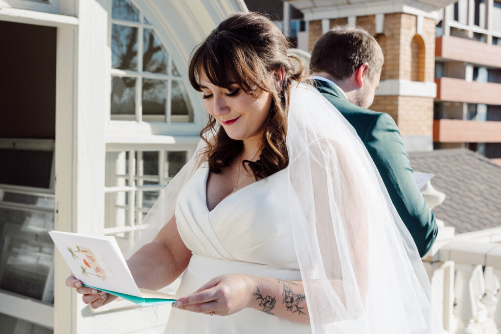 Bride reading a letter from her husband. They are back to back.