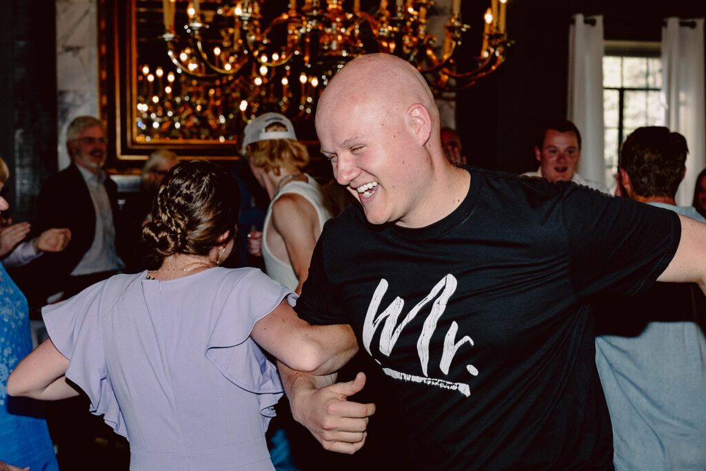 Groom dancing with wedding guests in a t-shirt