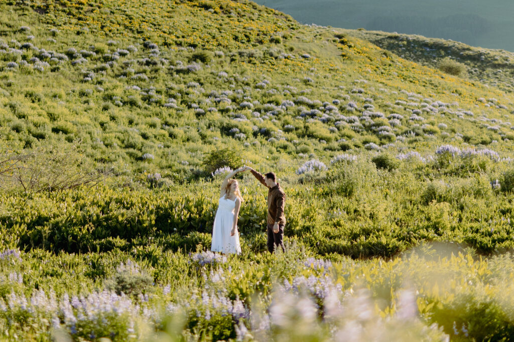 annie and chris in a field of wildflowers dancing