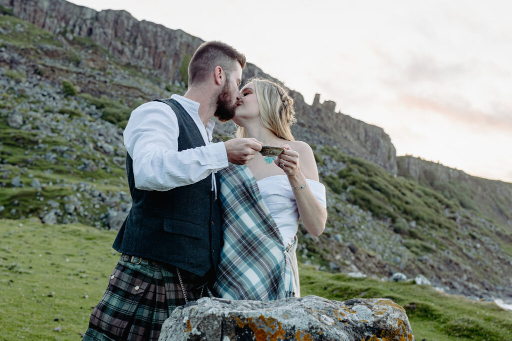 Bride and groom in scotish attire toasting drams