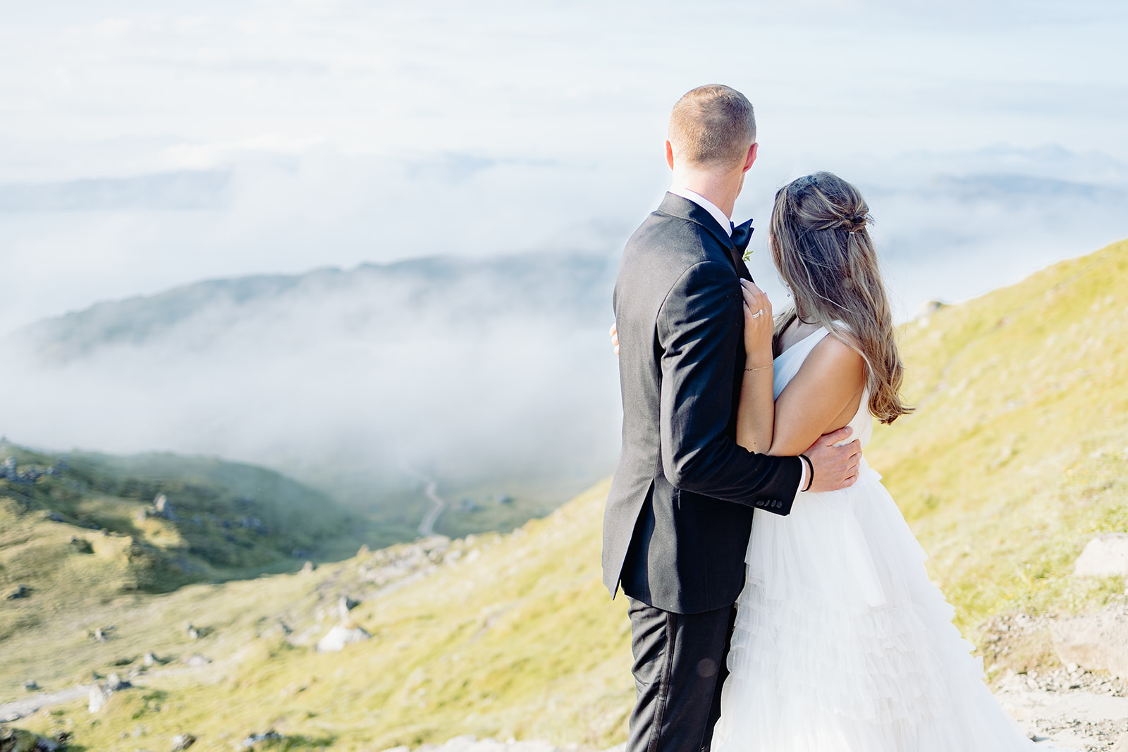 Bride and groom looking at cloudy sky
